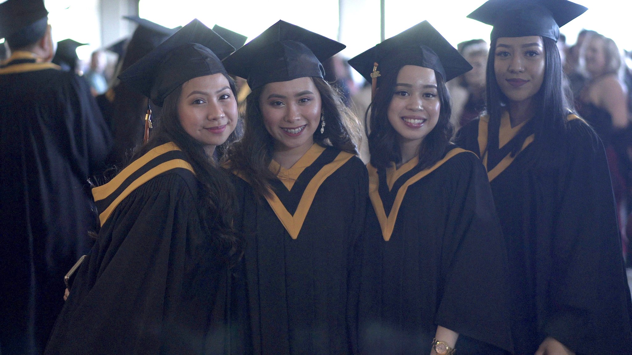 Four students in graduation caps and gowns