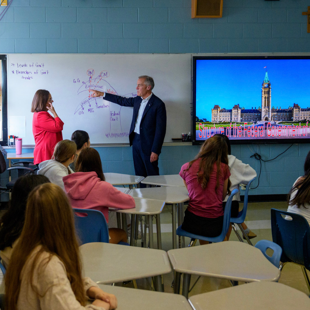 Prime Minister Mark Carney speaks to students in a classroom at St Rose Catholic Junior High School