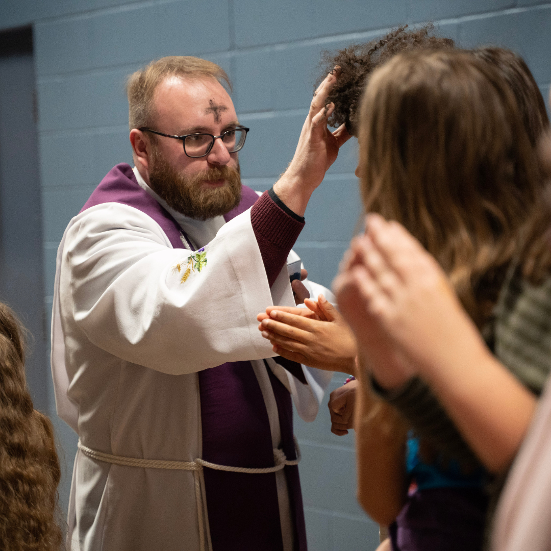 Ash Wednesday Father placing ashes on a student's forehead