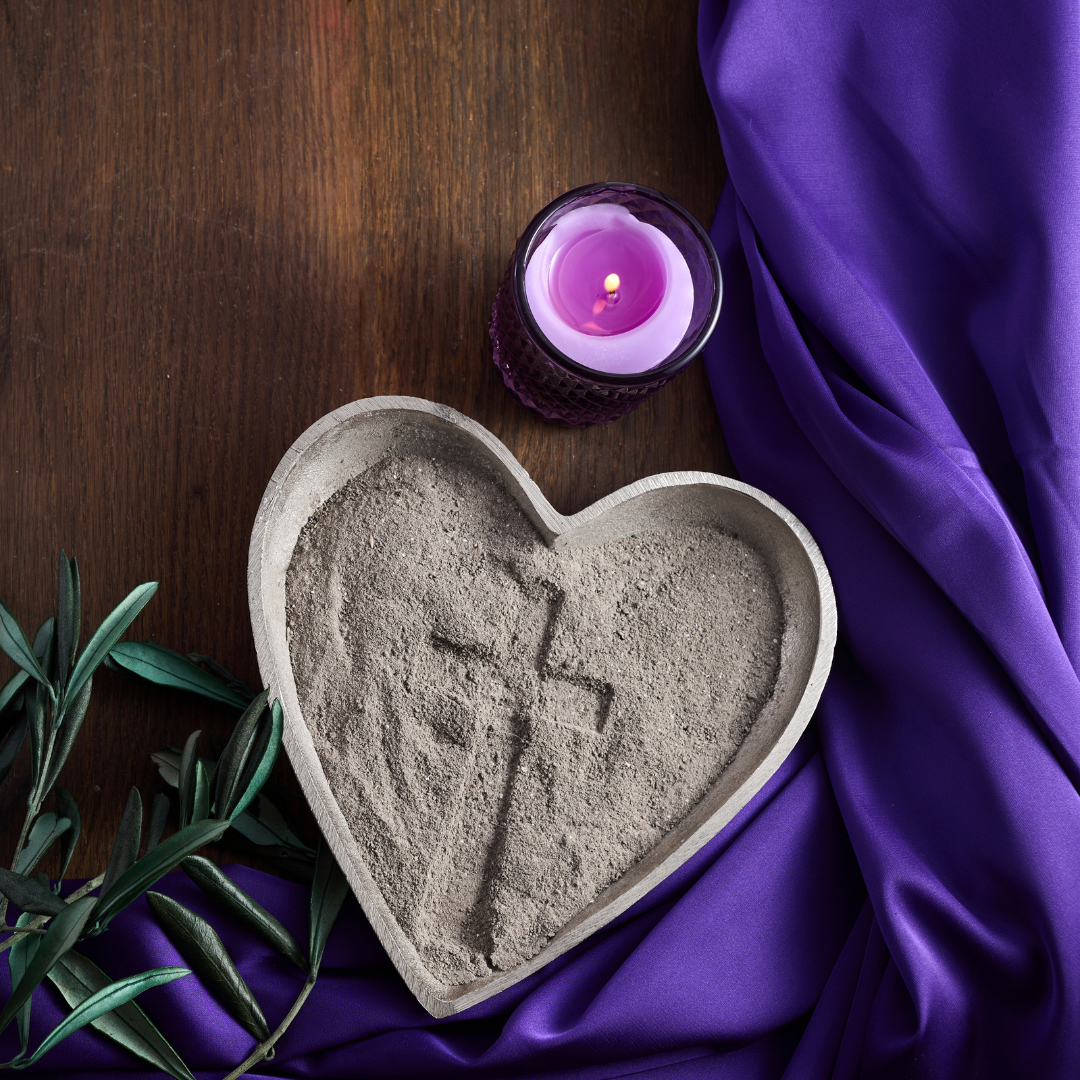 Ash Wednesday A heart shaped container with ashes and a cross created in the ashes