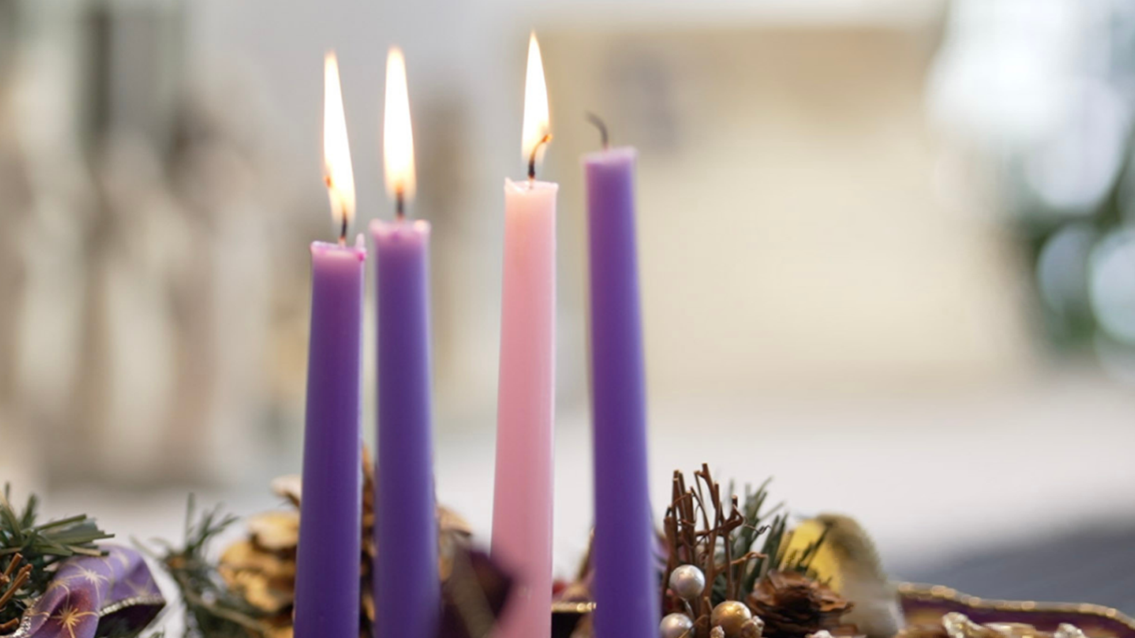 Advent Wreath with three candles lit, one purple candle remains unlit.