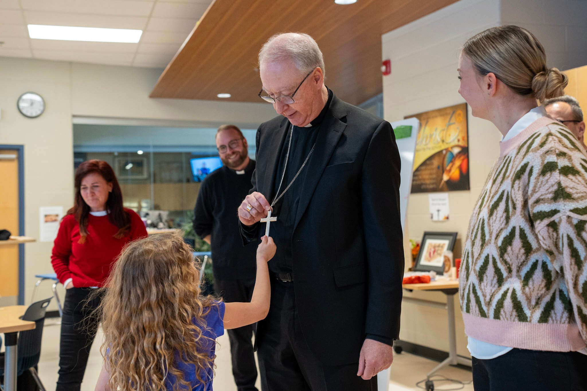 Archbishop Smith in a school with a student and staff