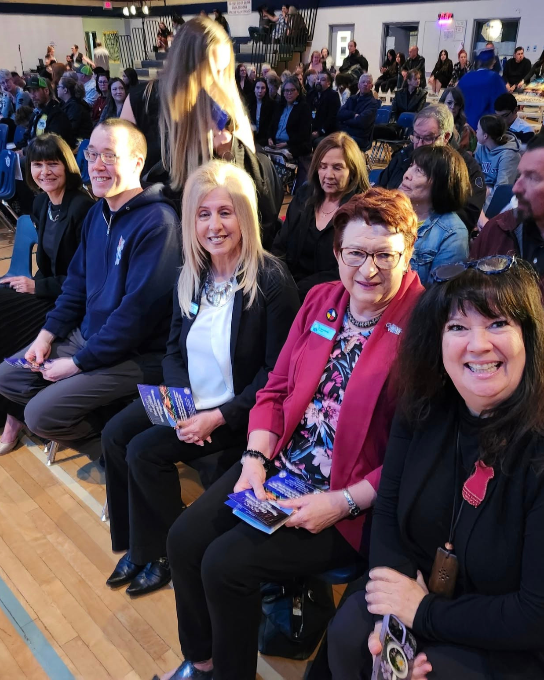 Trustees, Father Glenn, Chief Superintendent Anderson sitting in a gym for a graduation 