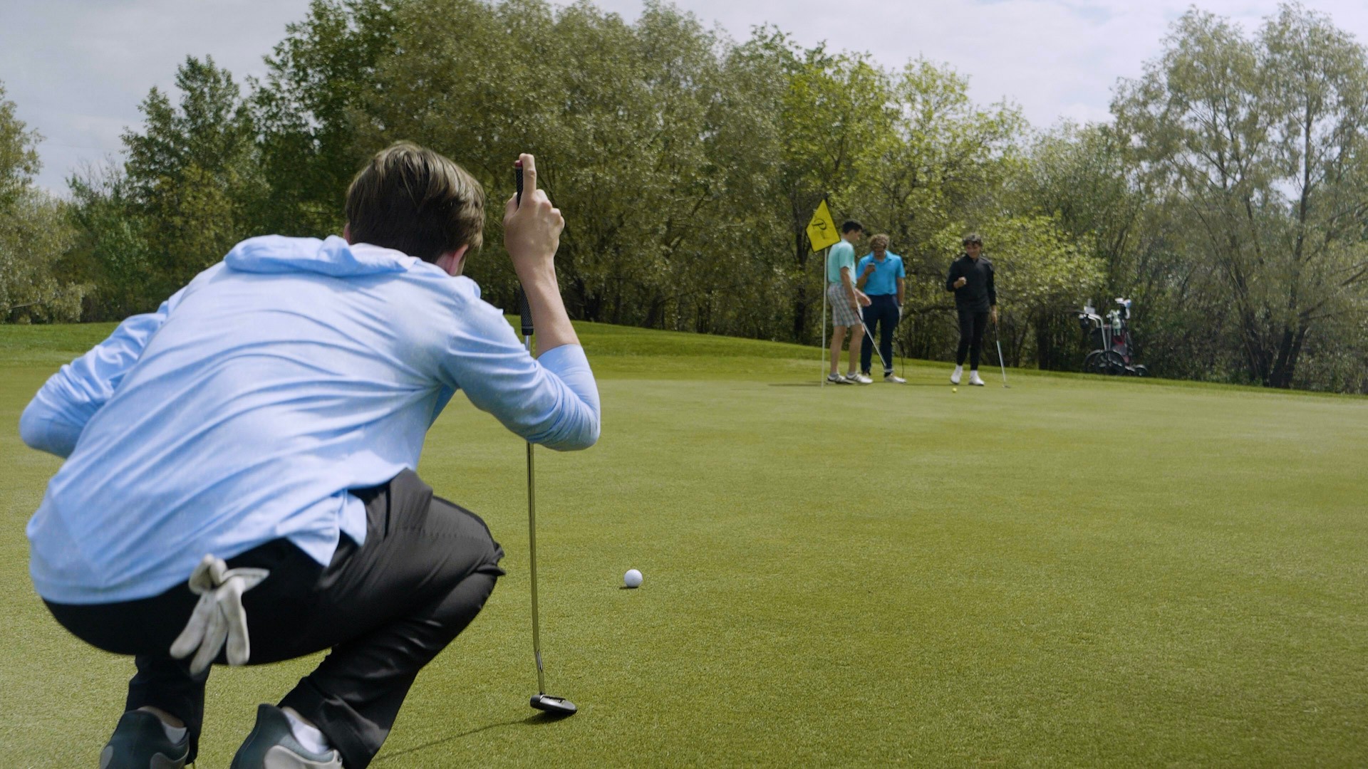 Golfer looking the hole, getting ready to putt the ball